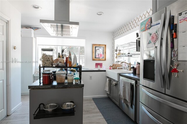 12301 SW 107th Ave, Miami, FL 33176 - kitchen featuring stainless steel fridge, a sink, dark countertops, light wood-style flooring, and island exhaust hood