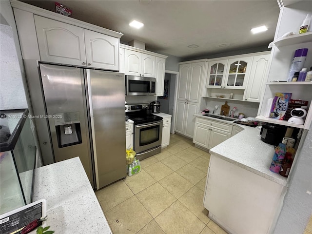 825 E 9th Ln, Hialeah, FL 33010 - kitchen featuring stainless steel appliances, open shelves, light tile patterned floors, white cabinets, and a sink