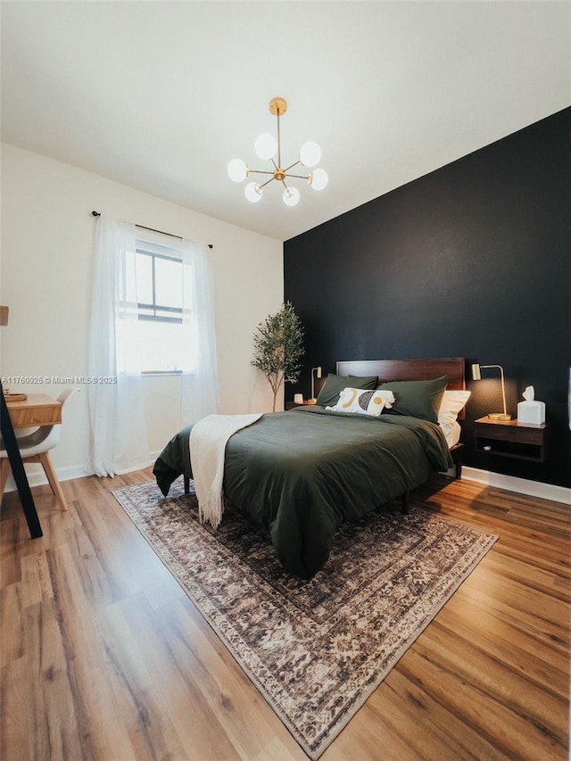 825 E 9th Ln, Hialeah, FL 33010 - bedroom featuring wood finished floors, a chandelier, and baseboards