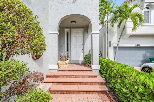 property entrance featuring stucco siding and an attached garage