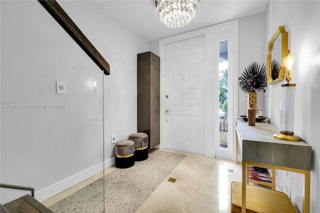 entrance foyer with a chandelier and baseboards