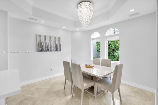 dining space featuring a chandelier, visible vents, baseboards, and a tray ceiling