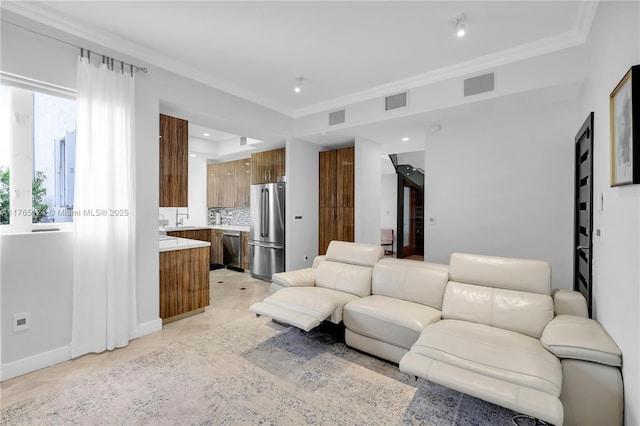 living room with baseboards, visible vents, and ornamental molding