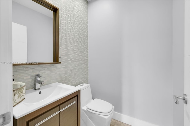 half bath with decorative backsplash, toilet, and vanity
