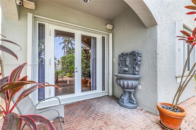entrance to property featuring stucco siding and french doors