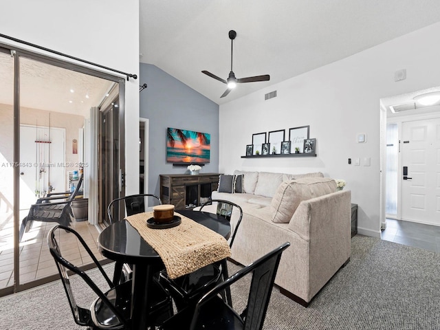living area featuring tile patterned floors, visible vents, lofted ceiling, and a ceiling fan