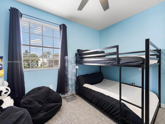 bedroom featuring carpet, a ceiling fan, and a textured ceiling