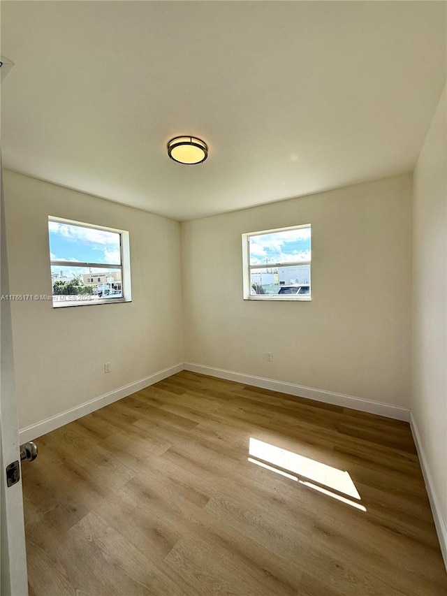 unfurnished room featuring baseboards and wood finished floors