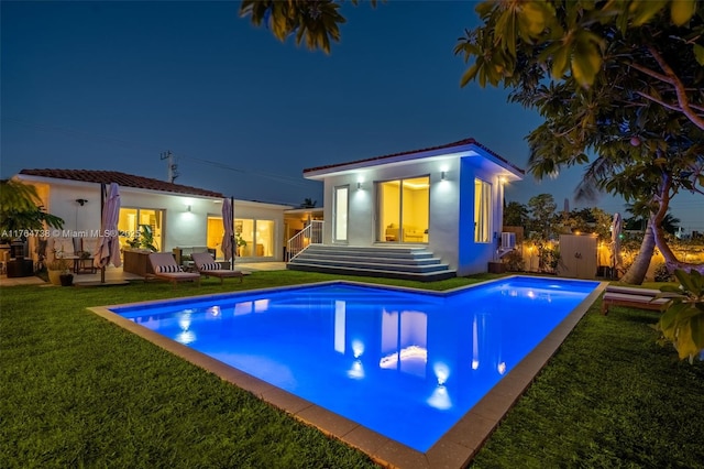 7770 Hawthorne Ave, Miami Beach, FL 33141 - pool at night featuring an outdoor pool and a yard
