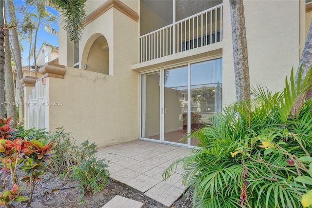 entrance to property with a patio area and stucco siding