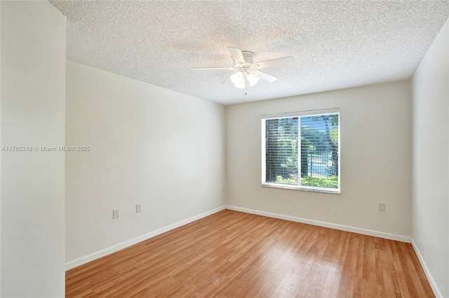 spare room with a textured ceiling, baseboards, light wood-style floors, and ceiling fan