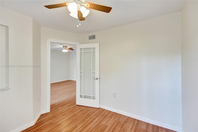 empty room with visible vents, baseboards, light wood-type flooring, and ceiling fan