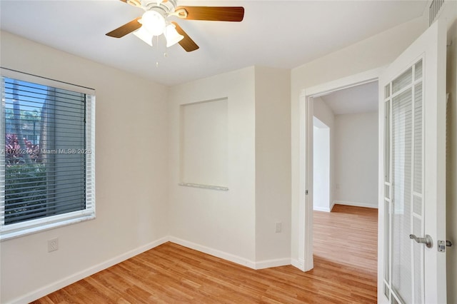 spare room featuring visible vents, light wood-style floors, baseboards, and ceiling fan