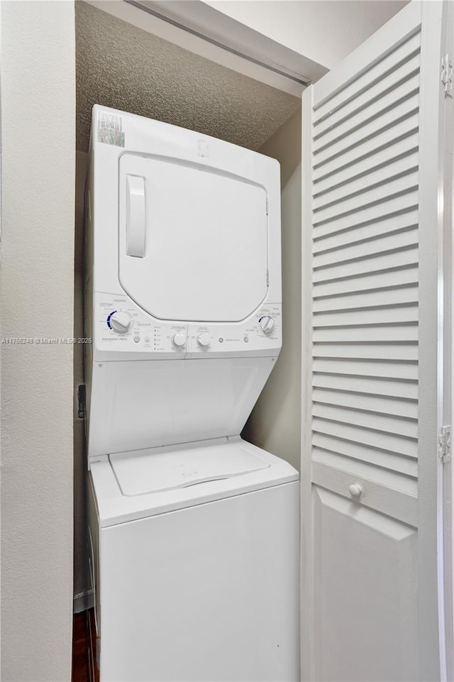 clothes washing area with laundry area and stacked washer / drying machine