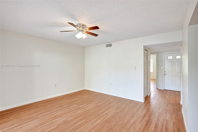 empty room with ceiling fan, visible vents, a textured ceiling, and light wood-style flooring