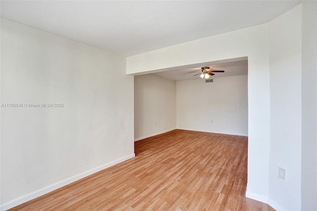 empty room featuring baseboards, light wood-style floors, and ceiling fan