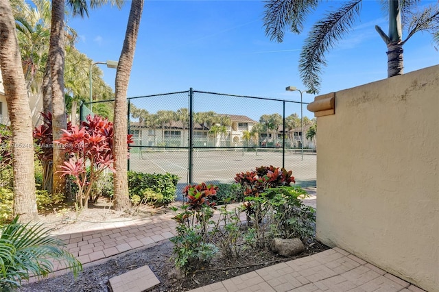 view of tennis court featuring fence