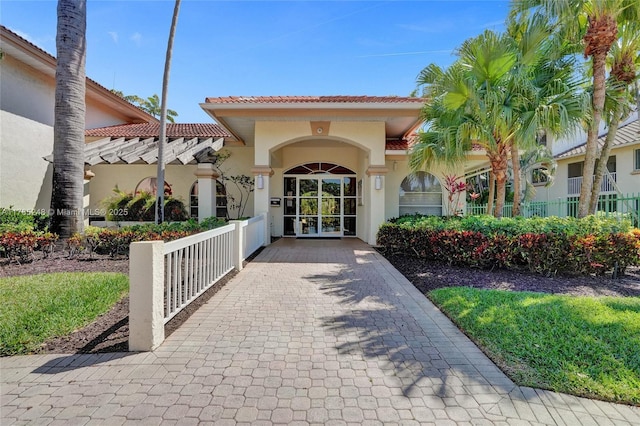 property entrance featuring stucco siding and a tile roof