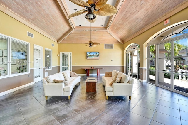 living room with a wealth of natural light, visible vents, wood ceiling, and ceiling fan