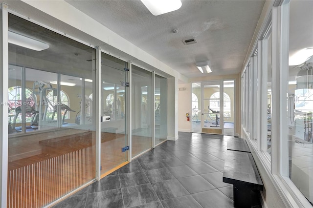 unfurnished sunroom featuring visible vents and french doors