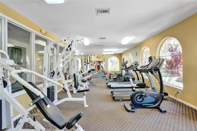 workout area with visible vents, baseboards, and carpet