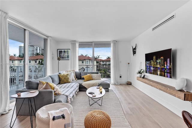 4000 NE 170th St Unit 300, North Miami Beach, FL 33160 - living area with a wealth of natural light, visible vents, light wood-type flooring, and expansive windows