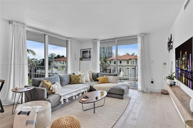 4000 NE 170th St Unit 300, North Miami Beach, FL 33160 - living area featuring plenty of natural light, light wood-style flooring, and expansive windows