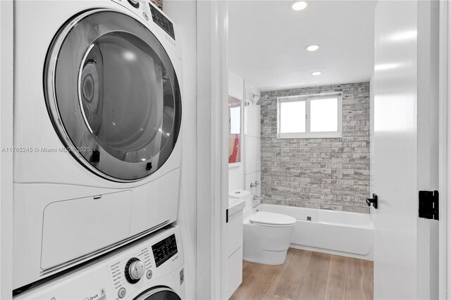 4000 NE 170th St Unit 300, North Miami Beach, FL 33160 - washroom with laundry area, stacked washer and clothes dryer, and light wood-style floors