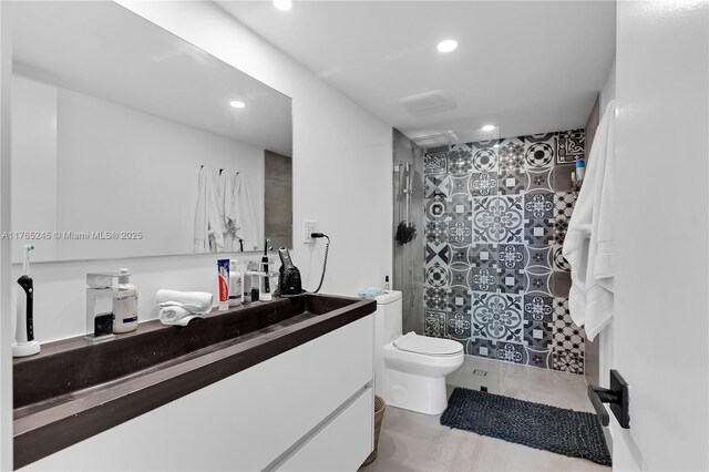 4000 NE 170th St Unit 300, North Miami Beach, FL 33160 - bathroom with toilet, a tile shower, recessed lighting, tile patterned flooring, and vanity