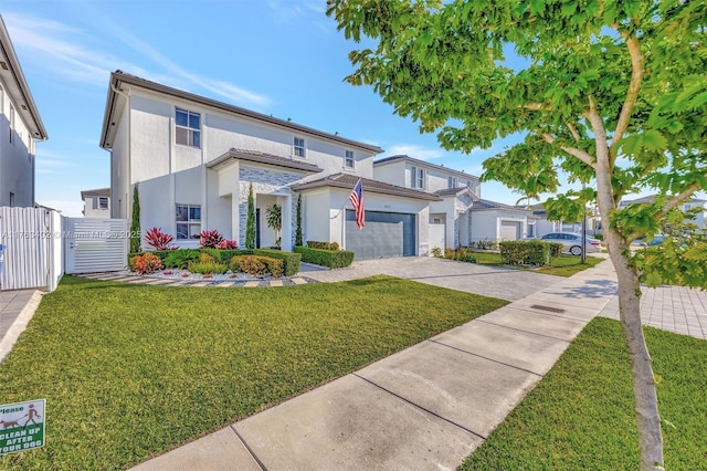 view of front of house with stucco siding, driveway, fence, a front yard, and a garage