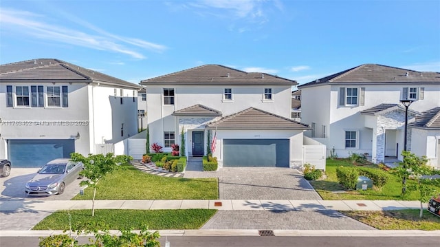 traditional home with stucco siding, a front lawn, decorative driveway, a garage, and a tiled roof