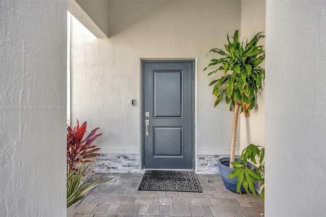 doorway to property featuring stucco siding