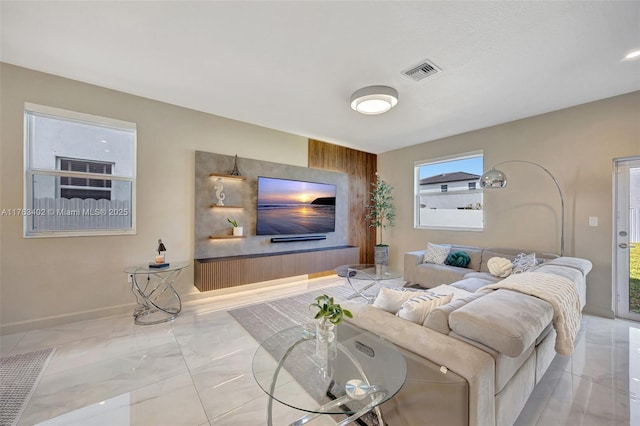 living area featuring visible vents, baseboards, and marble finish floor