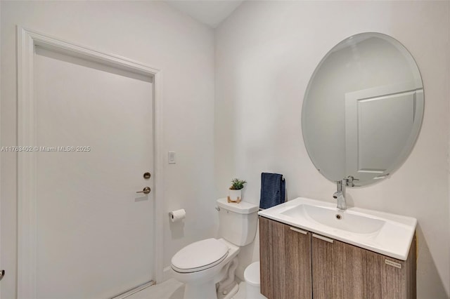 half bath featuring baseboards, toilet, and vanity