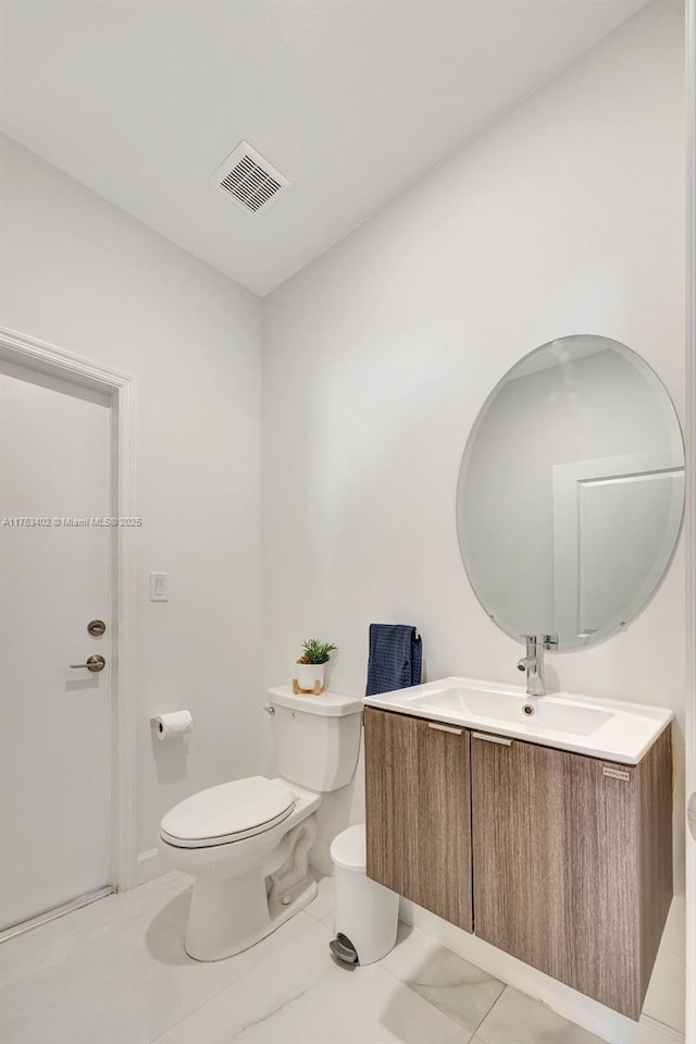 half bathroom with visible vents, toilet, and vanity