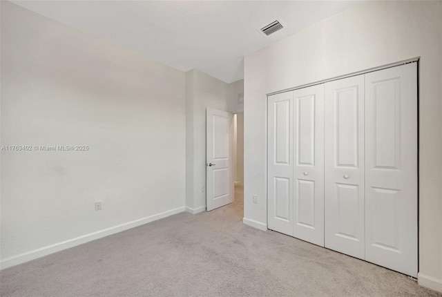 unfurnished bedroom featuring visible vents, baseboards, carpet, and a closet