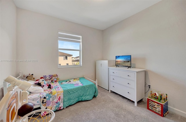 bedroom featuring light carpet and baseboards