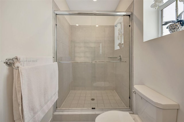 full bath featuring a stall shower and toilet