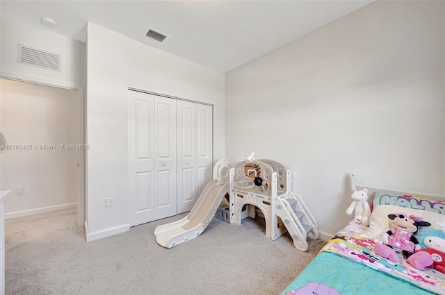 carpeted bedroom with a closet, visible vents, and baseboards