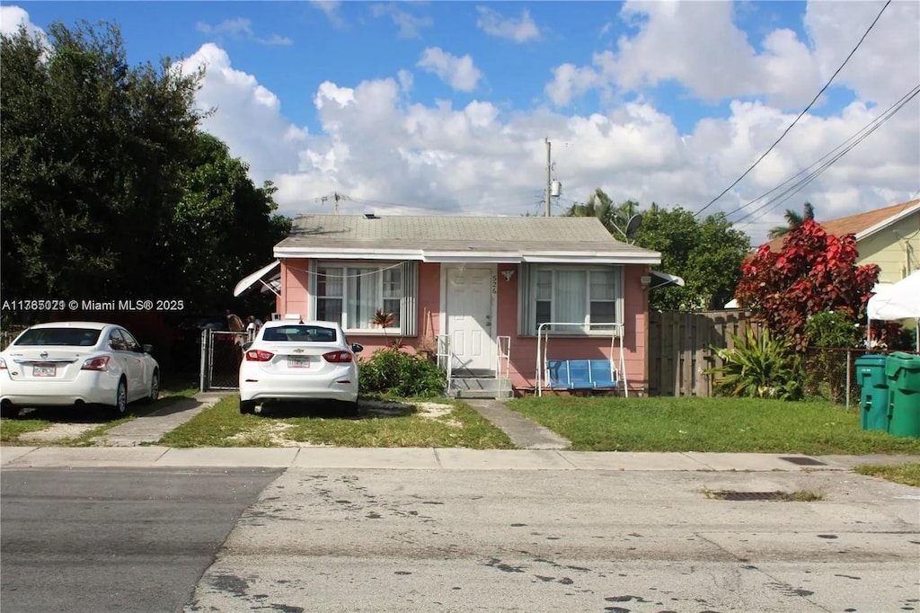 bungalow-style house with a front yard and fence