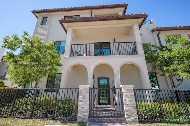 8321 Central Park Blvd, Doral, FL 33166 - view of front of property featuring stucco siding, a balcony, a fenced front yard, and a tiled roof