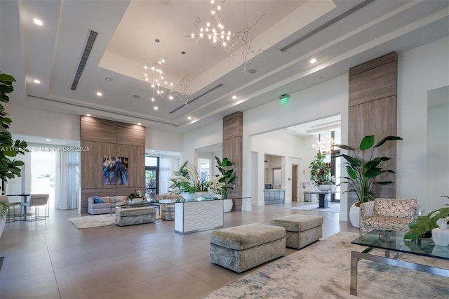 8321 Central Park Blvd, Doral, FL 33166 - living room featuring visible vents, ornate columns, a tray ceiling, a high ceiling, and a notable chandelier