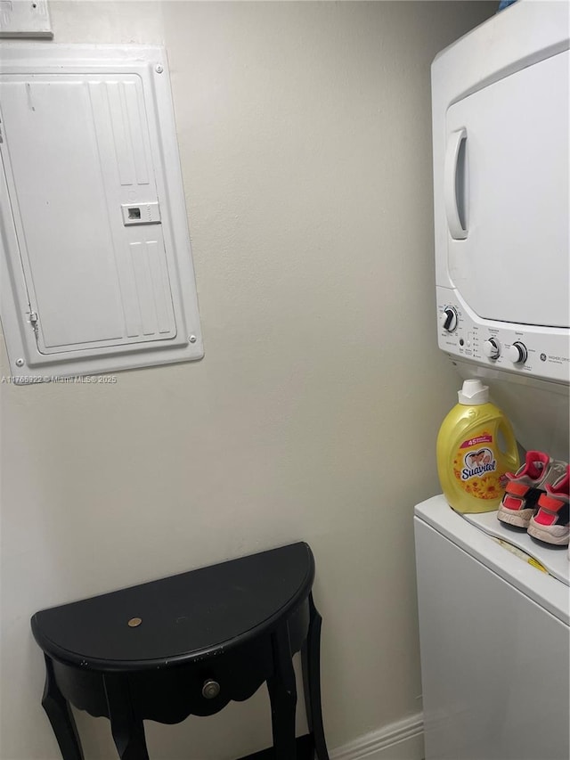 laundry area featuring electric panel, laundry area, and stacked washer and clothes dryer