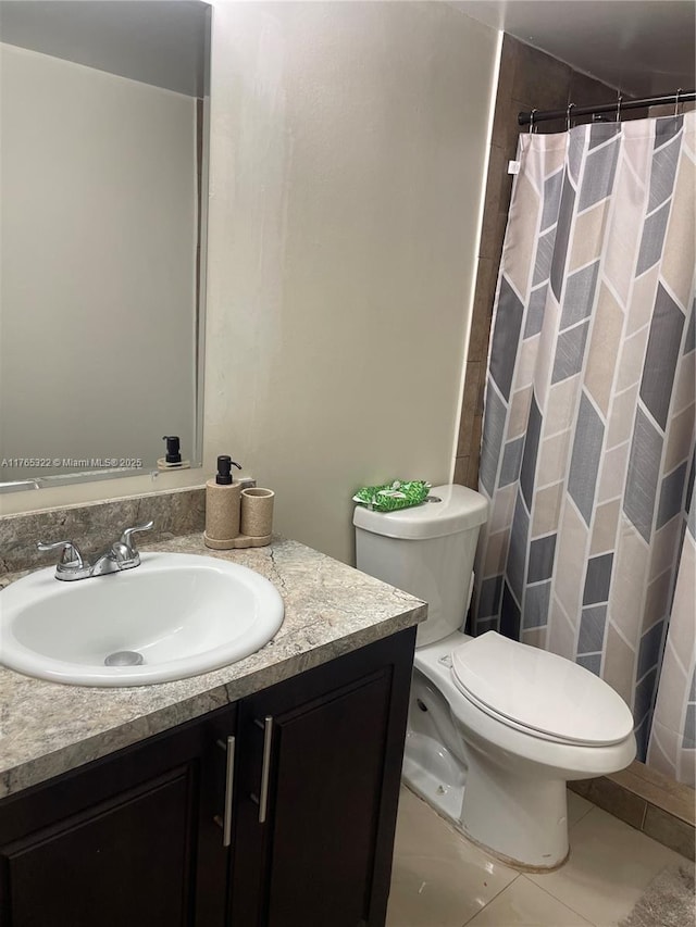 full bathroom with tile patterned floors, toilet, curtained shower, and vanity