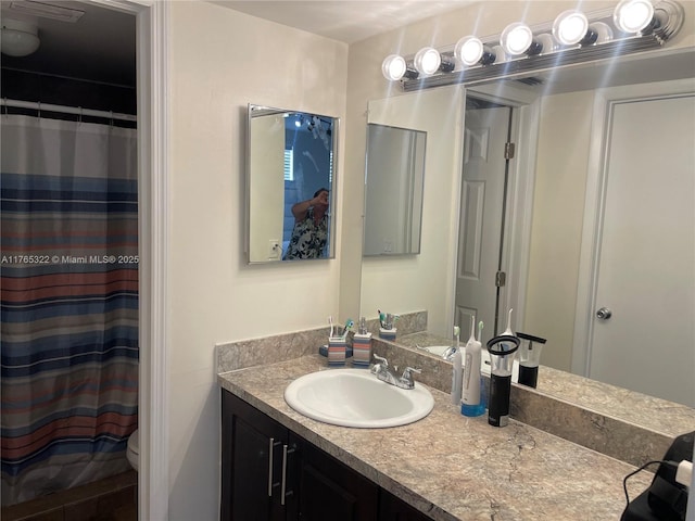 bathroom featuring a shower with curtain, toilet, and vanity