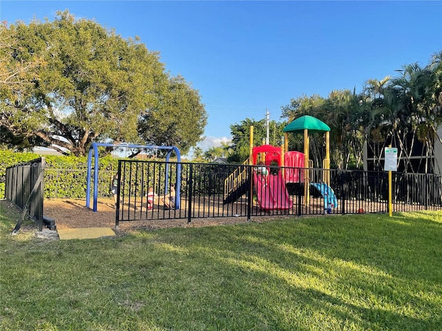 community jungle gym featuring a lawn and fence