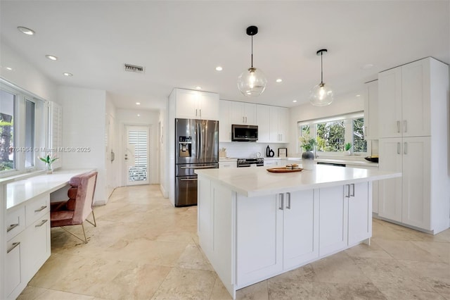 13575 SW 72nd Ave, Pinecrest, FL 33156 - kitchen featuring appliances with stainless steel finishes, white cabinets, a kitchen island, light countertops, and recessed lighting
