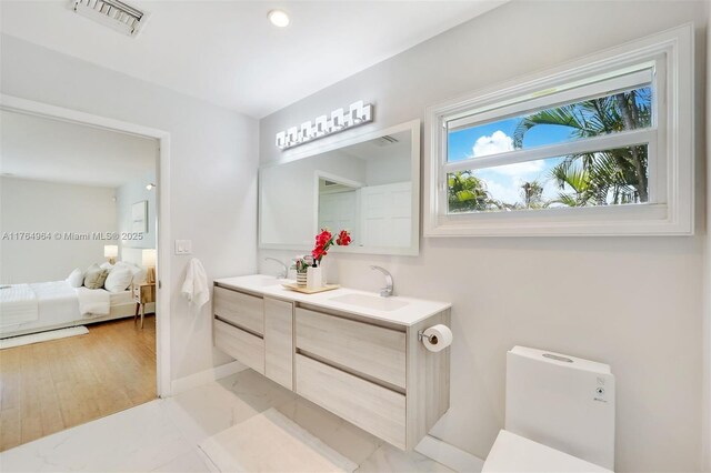 13575 SW 72nd Ave, Pinecrest, FL 33156 - ensuite bathroom featuring double vanity, marble look tiles, and recessed lighting