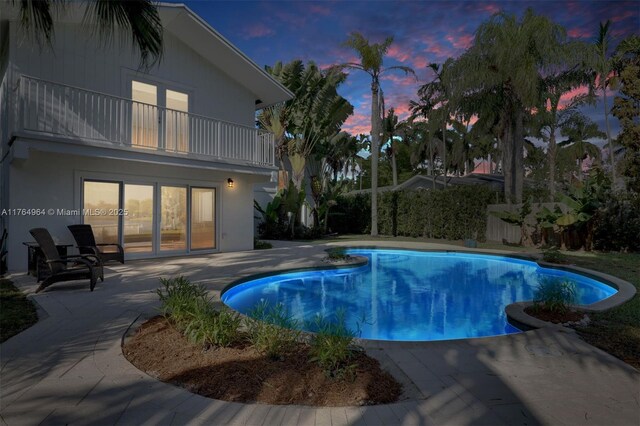 13575 SW 72nd Ave, Pinecrest, FL 33156 - pool at dusk featuring a patio area and an outdoor pool