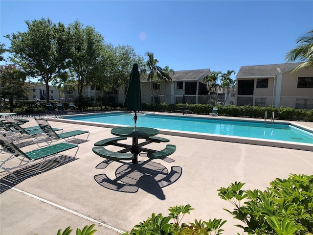 pool with a patio and fence